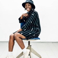 portrait of woman in striped dress sitting on stool - fashion stock pictures, royalty-free photos & images
