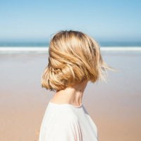 portrait of woman looking at the ocean beach. - hairstyle stock pictures, royalty-free photos & images