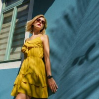 portrait of woman smiling against wall with palm tree shade - fashion stock pictures, royalty-free photos & images