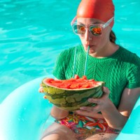 portrait of woman with floating tire and watermelon in swimming pool - fashion stock pictures, royalty-free photos & images