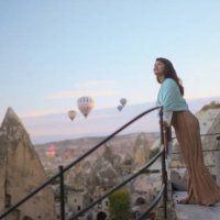 portrait of young female tourist watching hot air ballons from balcony in cappadocia during her travel - travel stock pictures, royalty-free photos & images