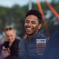 portrait of young guy at festival holding beer - concert stockfoto's en -beelden