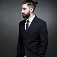 portrait of young man wearing black jacket and jogging pants in front of grey background - hairstyle stock pictures, royalty-free photos & images
