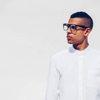 portrait of young man with shaved hair and glasses wearing white shirt in front of white background - hairstyle stock pictures, royalty-free photos & images
