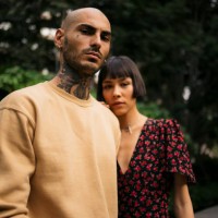 portrait of young serious couple standing in the park - fashion stockfoto's en -beelden