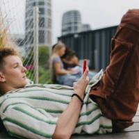 portrait of young stylish generation z boy browsing on smartphone. - fashion stock pictures, royalty-free photos & images