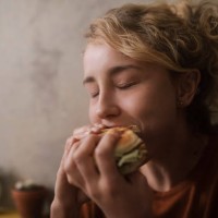 portrait of young woman eating hamburger - food stock pictures, royalty-free photos & images