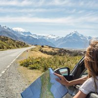 portrait of young woman in car looking at map - travel stock pictures, royalty-free photos & images