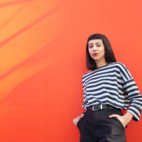 portrait of young woman standing against red background. - fashion stock pictures, royalty-free photos & images