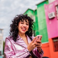 portrait of young woman using mobile phone outdoors - fashion stock pictures, royalty-free photos & images