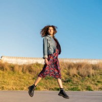 portrait of young woman with curly brown hair jumping in the air - fashion stock pictures, royalty-free photos & images