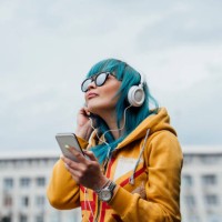 portrait of young woman with dyed blue hair listening music with smartphone and headphones - fashion stock pictures, royalty-free photos & images