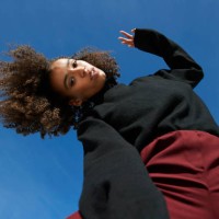portrait of young woman with head cocked against blue sky - fashion stock pictures, royalty-free photos & images