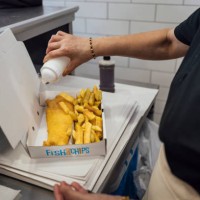 pouring salt on fish and chips - junk food stock pictures, royalty-free photos & images