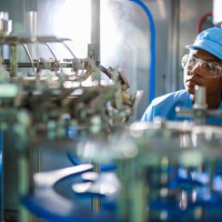 precision in progress: african female engineer in professional uniform working with digital tablet overseeing quality control in beverage manufacturing facility - food stock pictures, royalty-free photos & images