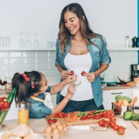 pregnant mother and daughter making vegetable smiley face - food stock pictures, royalty-free photos & images