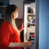 pregnant woman in front of the open fridge in the middle of the night - junk food stock pictures, royalty-free photos & images
