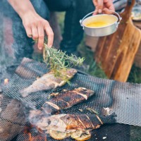 preparing fish for cooking over open campfire - food stock pictures, royalty-free photos & images