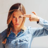 pretty woman pointing her finger to her head - hairstyle stockfoto's en -beelden