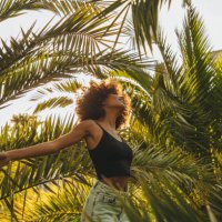 pretty young afro woman among palm trees - travel stockfoto's en -beelden