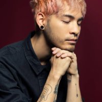 primer plano de un joven reflexivo con las manos entrelazadas - hairstyle fotografías e imágenes de stock
