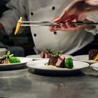 professional chef at work in a busy kitchen getting ready for service - food stock pictures, royalty-free photos & images