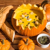 pumpkin soup in shell served with bread and roasted pumpkin seeds - food stock pictures, royalty-free photos & images