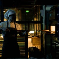 putting pizza into the baking oven! - junk food stock pictures, royalty-free photos & images