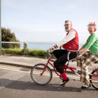 quirky couple sightseeing on tandem bicycle, bournemouth, england - fashion stock pictures, royalty-free photos & images