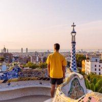 rear view of a man in yellow shirt looking at barcelona skyline from above, spain - travel stock pictures, royalty-free photos & images