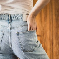 rear view of a woman wearing denim trousers - fashion stock pictures, royalty-free photos & images