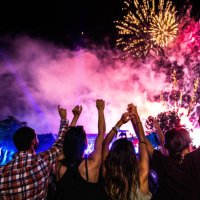 rear view of crowd of people watching fireworks at night. - concert stock pictures, royalty-free photos & images