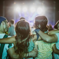 rear view of embraced friends on a music concert at night. - concert stock pictures, royalty-free photos & images
