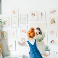 rear view of female artist hanging paintings on wall in studio - home decoration stock pictures, royalty-free photos & images