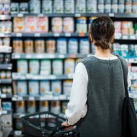 rear view of young asian mother with a shopping cart grocery shopping for baby products in a supermarket. she is standing in front of the baby product aisle and have no idea which product to choose from - food stock pictures,