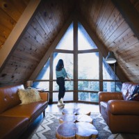 rear view of young woman looking out picture window - home decoration stock-fotos und bilder