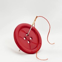 red button with four thread holes and a needle with thread - fashion stock pictures, royalty-free photos & images