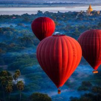 red hot air balloons over jungle, nyaung-u, mandalay region, myanmar - travel stock-fotos und bilder