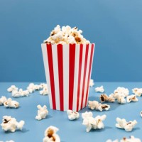 red paper striped bucket with popcorn on the blue background - junk food stock pictures, royalty-free photos & images