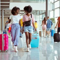 reisende, die mit gepäck am flughafen spazieren gehen - travel stock-fotos und bilder