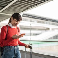 reisende junge frau mit handy in einer u-bahn-station - travel stock-fotos und bilder