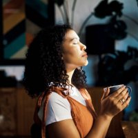 relax, peace and coffee with a woman drinking a drink of caffeine and meditating in her home with her eyes closed. mental health, wellness and zen with a young female enjoying calm, quiet tranquility - coffee stock pictures, 