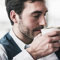 relaxed young man drinking cup of coffee - coffee stockfoto's en -beelden