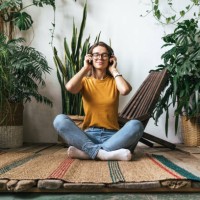 relaxed young woman sitting on the floor at home listening to music - home decoration stock pictures, royalty-free photos & images