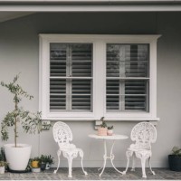 relaxing area with table set and flower pot near window in patio, garden, grey and white background - garden decoration stock pictures, royalty-free photos & images
