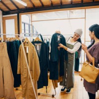 retail shop clerk helping a mid adult woman customer shop for clothing in a boutique - fashion stock pictures, royalty-free photos & images