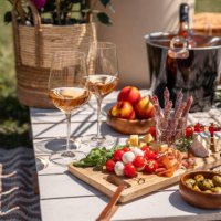 rose wine glasses with antipasti picnic food snacks on sunny garden party table - food stock pictures, royalty-free photos & images