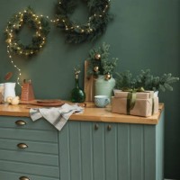 rustic kitchen decorated for christmas with fir wreaths, fir decorations, christmas baubles and illuminated fairy lights - home decoration stock pictures, royalty-free photos & images