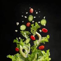 salad ingredients flying through the air, landing in a bowl - food stock pictures, royalty-free photos & images