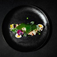 salad on a black plate on a black background - food stock pictures, royalty-free photos & images